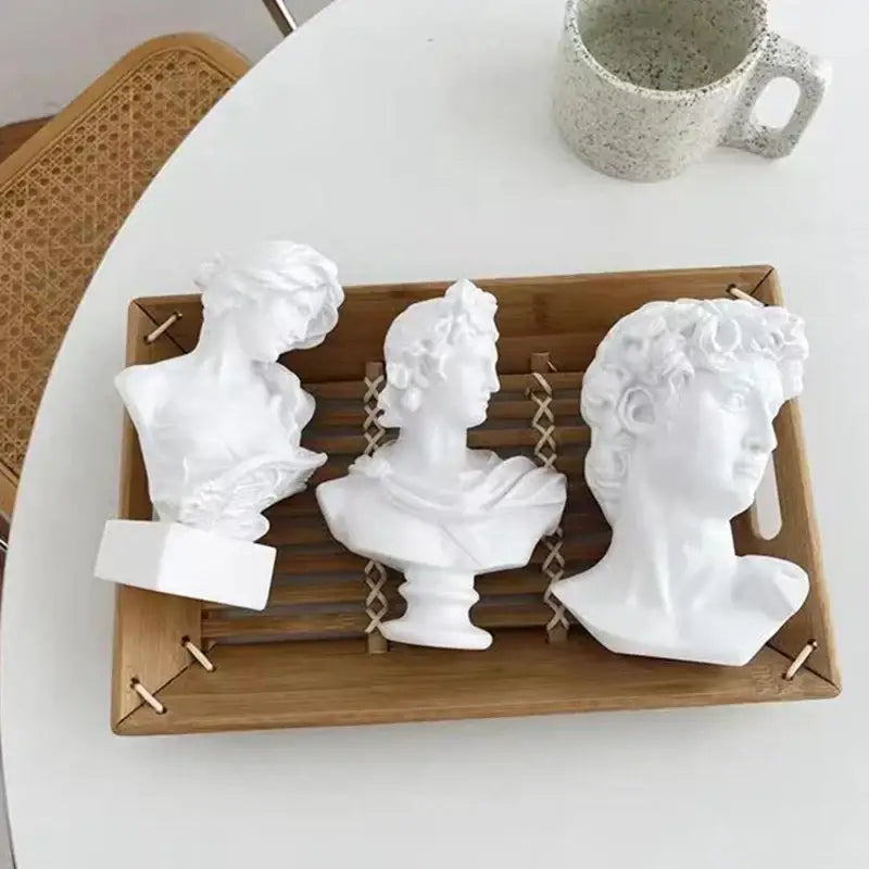 Three white ceramic david statue head sculptures arranged on a wooden tray for mini living room decor