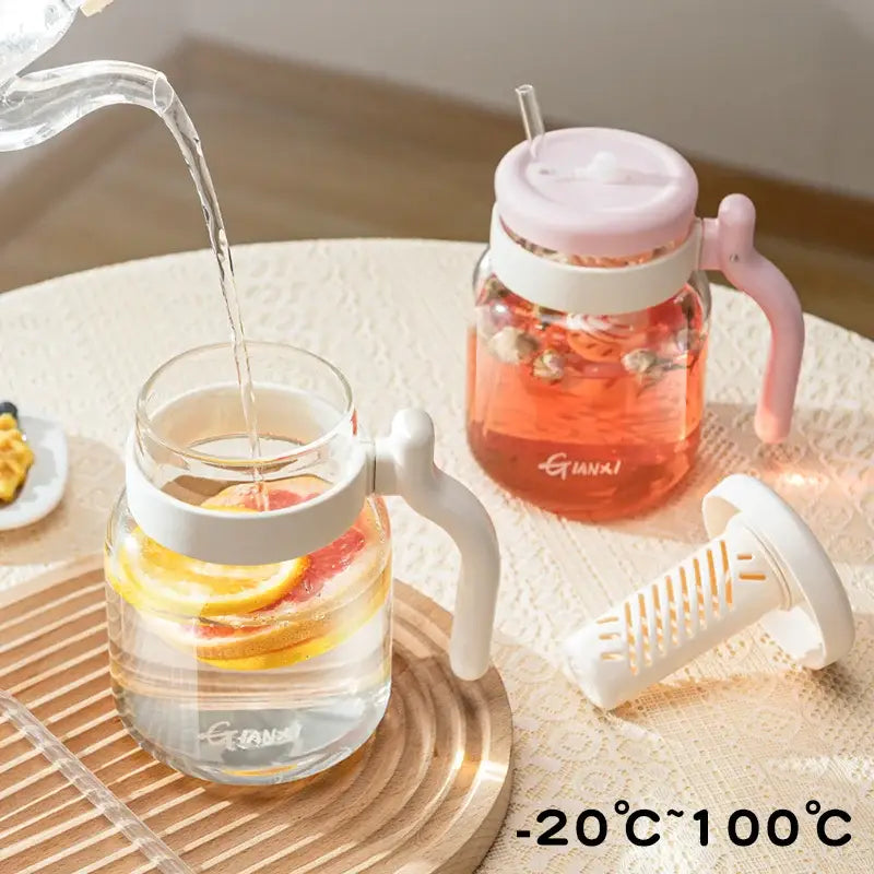 Clear 1000ml glass tumbler with handle and straw kitchen water bottle filled with orange herbal tea and citrus slices