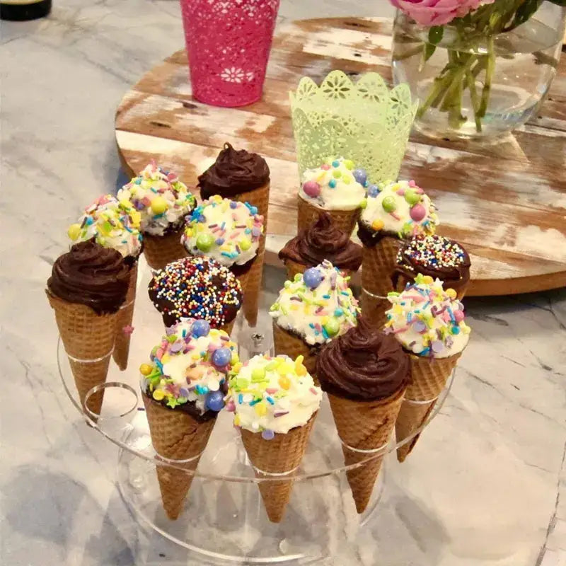 Clear acrylic cone holder stand displaying mini ice cream cones with chocolate and vanilla frosting and colorful sprinkles