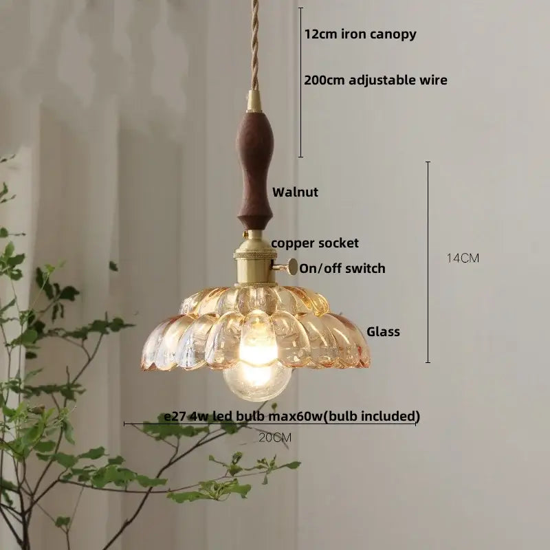 A warm-toned pendant lamp with decorbites amber glass, walnut handle, and brass accents featuring an adjustable wire