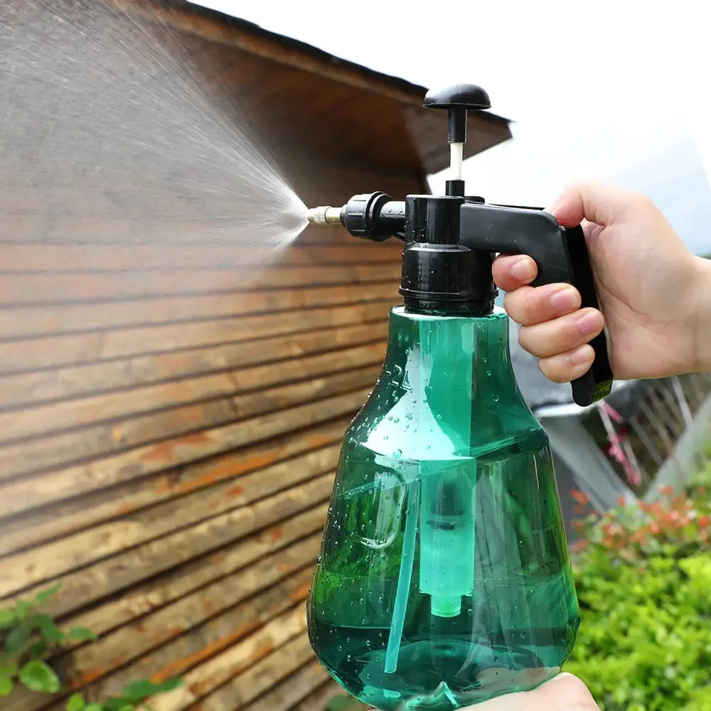 Green plastic watering sprayer with black hand trigger and pump mechanism for garden and flower care