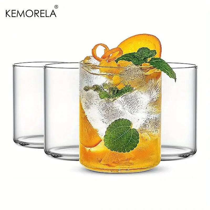 Clear borosilicate drinking glass filled with orange cocktail garnished with mint and citrus in drinking glasses set