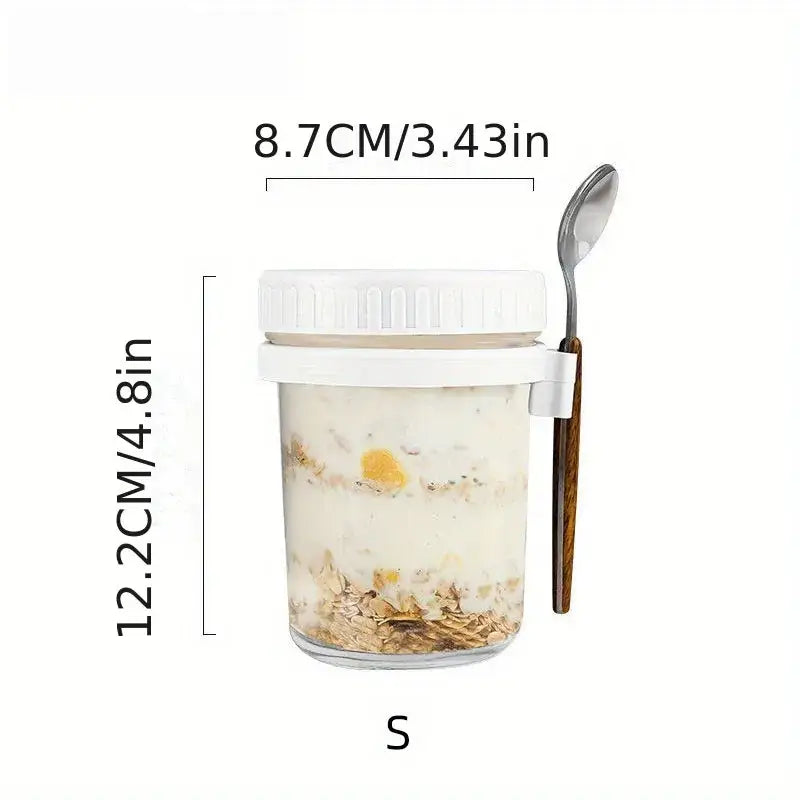 Clear borosilicate drinking glass jar with white lid and wooden spoon containing layered oatmeal in drinking glasses set