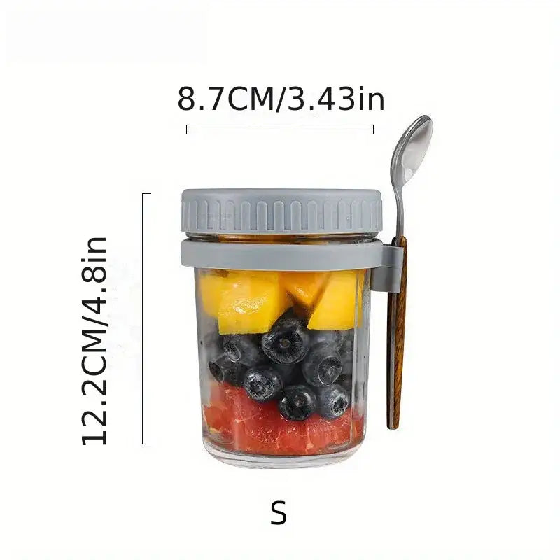 Clear borosilicate drinking glass jar with gray lid and wooden spoon filled with layered fruit from drinking glasses set