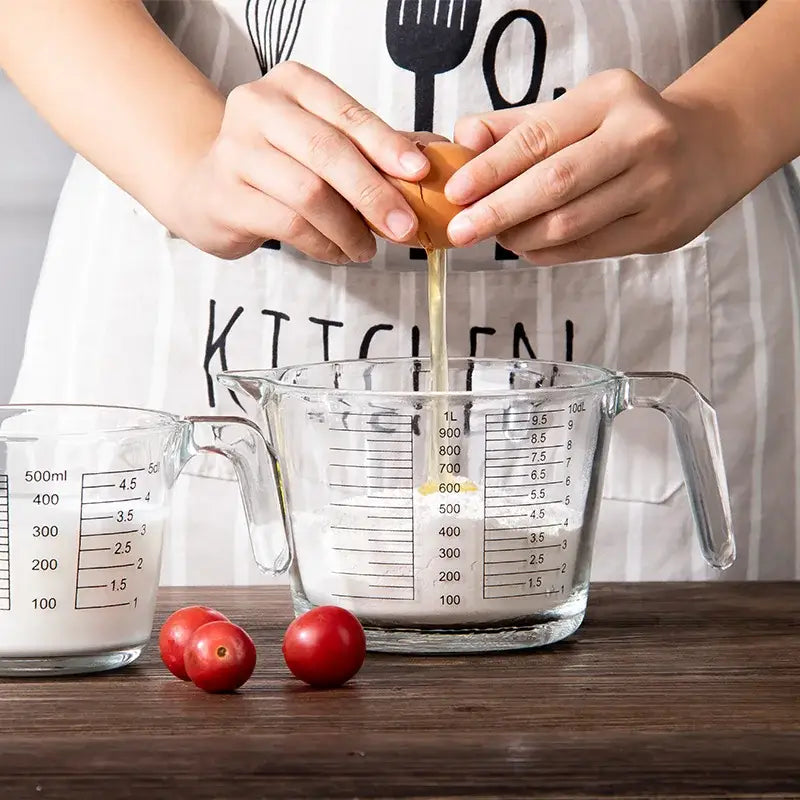 Clear borosilicate glass measuring cup by decorbites filled with white liquid featuring black measurement markings and a handle