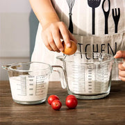 Clear borosilicate glass measuring cups with black markings holding milk and flour for kitchen baking by decorbites borosilicate glass