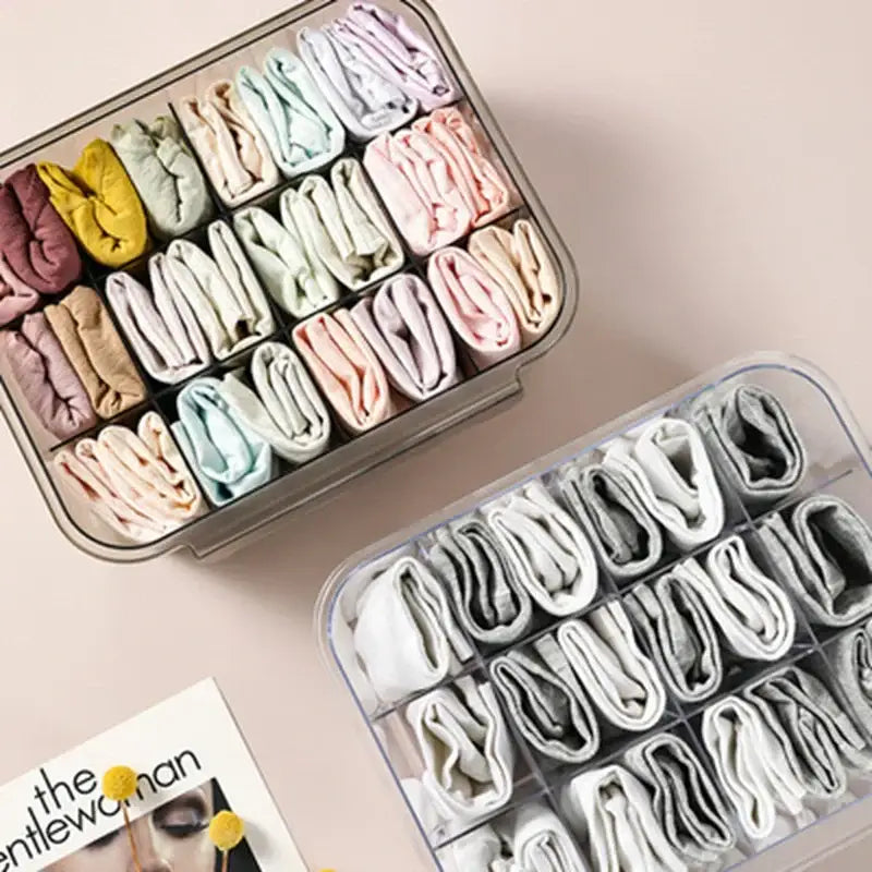 Clear divided plastic drawer closet organizer with transparent compartments holding pastel-colored folded socks