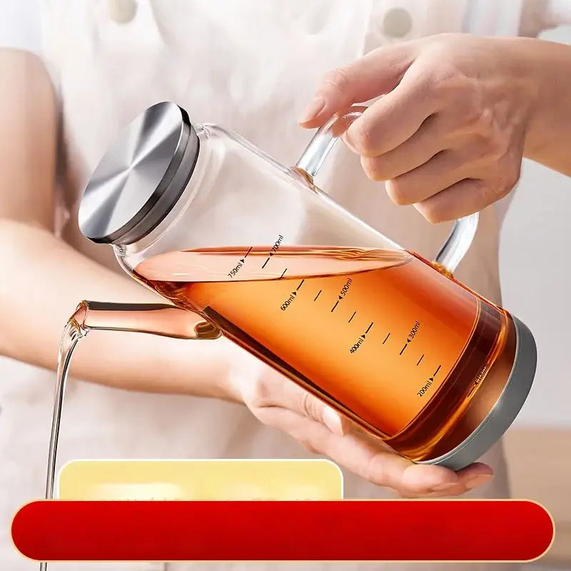 Clear glass and silver condiment bottle set featuring a glass oil dispenser with measurement markings in milliliters