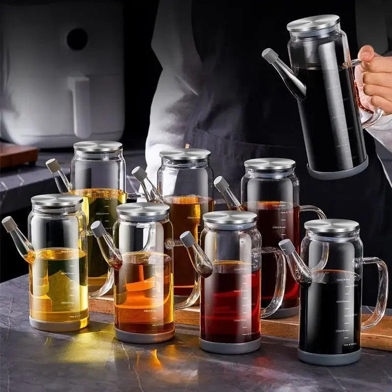 Clear glass and silver condiment bottle set with handles and gray bases for kitchen oil dispensers