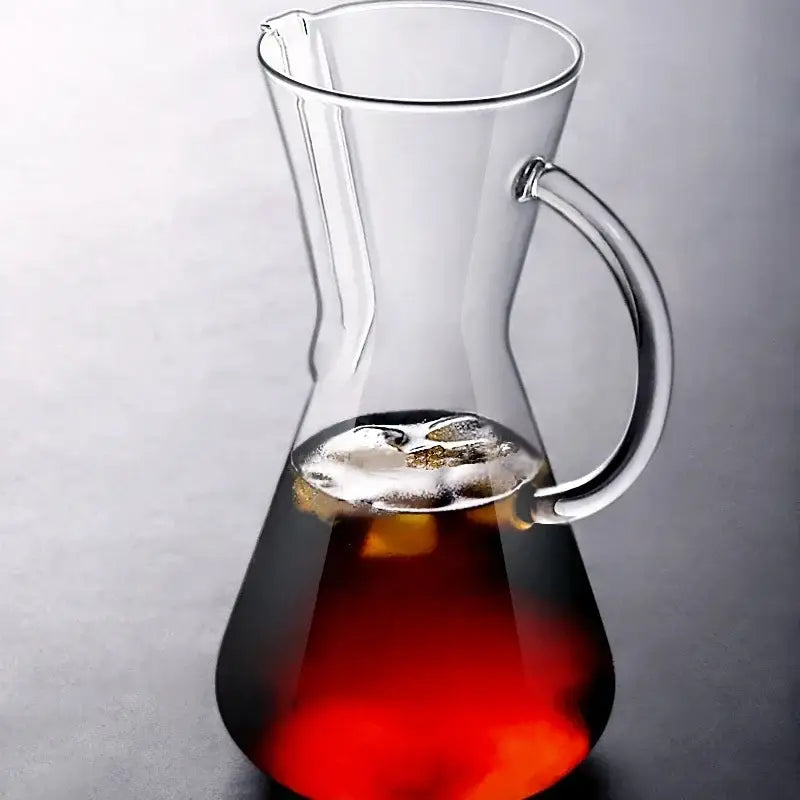Clear glass barista kettle pot pour over coffee set with curved handle filled with dark red liquid by decorbites barista kettle
