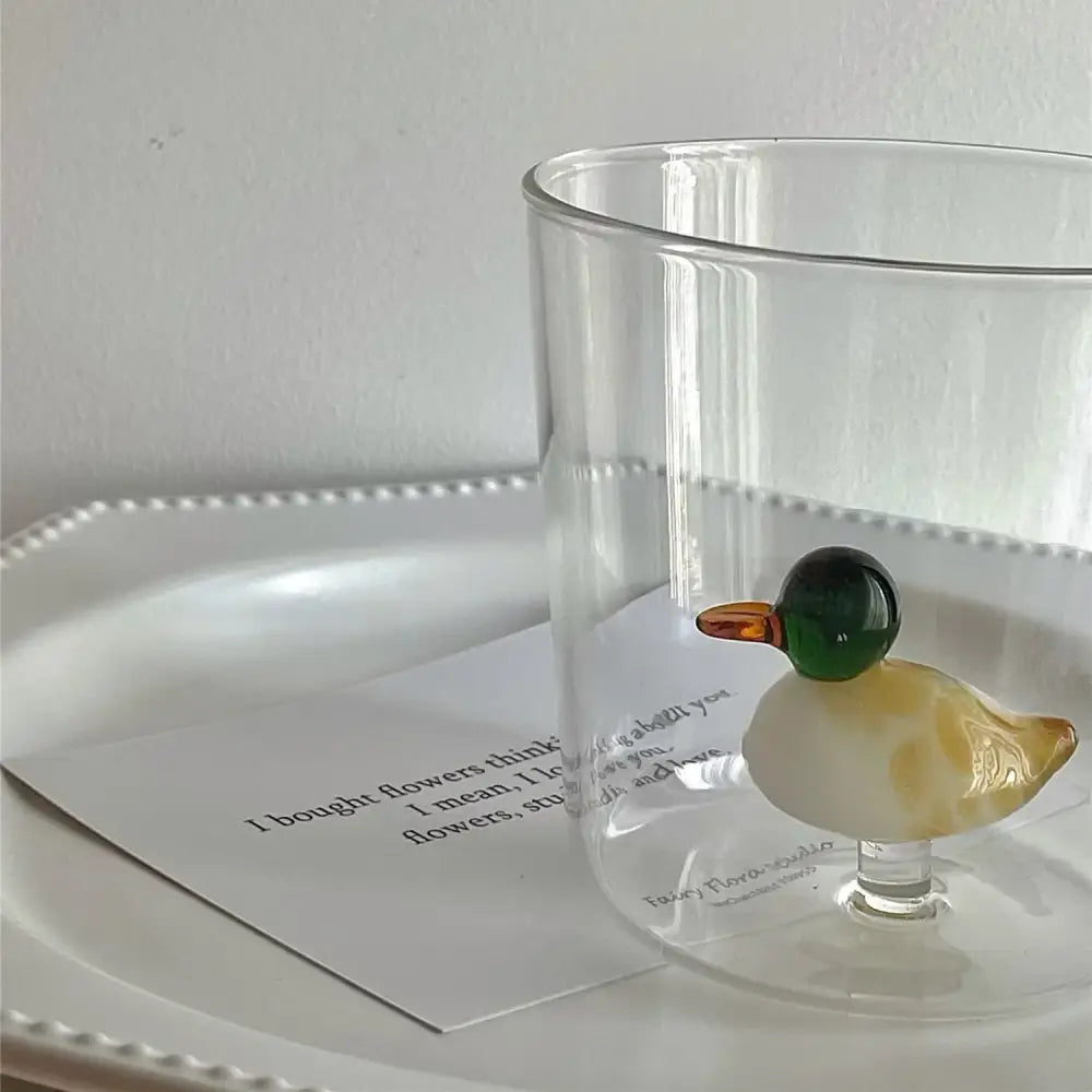 Translucent glass cup decorated as a decorbites cactus bunny duckling with a green head amber beak cream body swirl