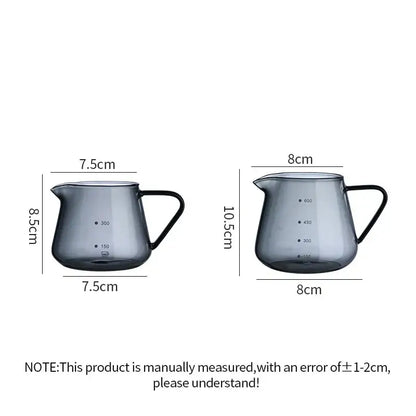 Two dark gray glass coffee pots with black handles and clear measurement markings for precise kitchen use