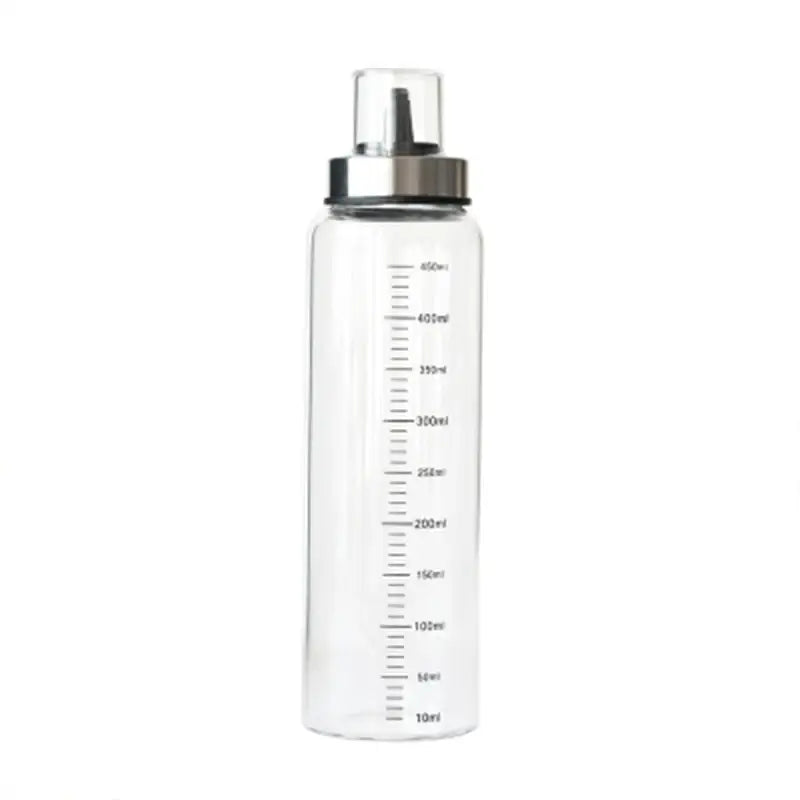 Clear plastic water bottle with silver metal cap and milliliter markings in a glass condiment bottle set for kitchen use