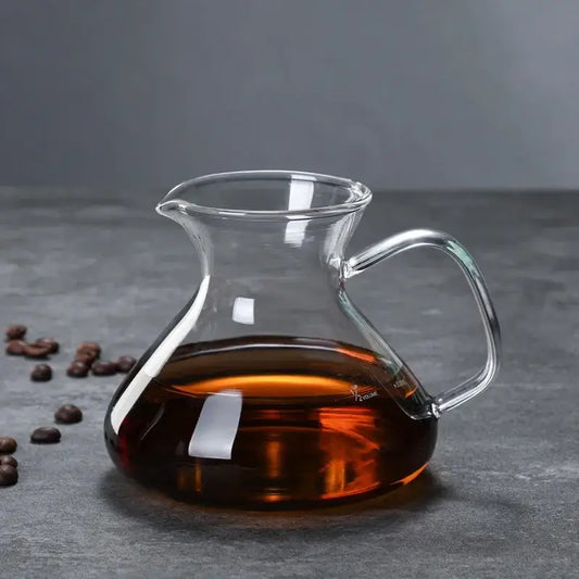 Clear glass drip pot coffee carafe filled with dark amber liquid from a kitchen pot coffee set with filter