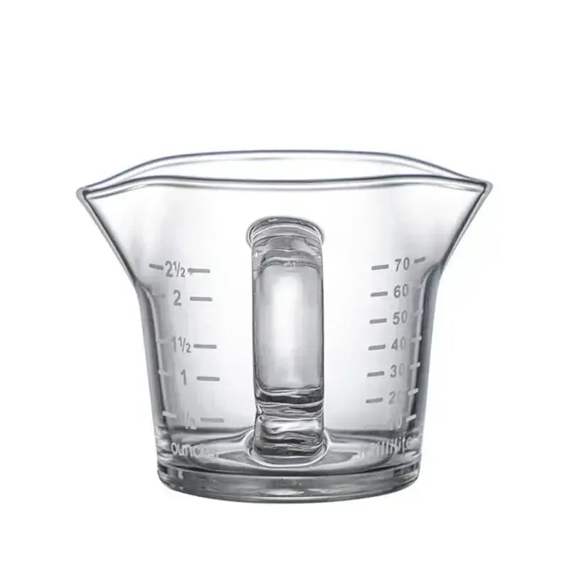 Clear glass espresso measuring cup with handle and graduated markings in ounces and milliliters for precise measuring