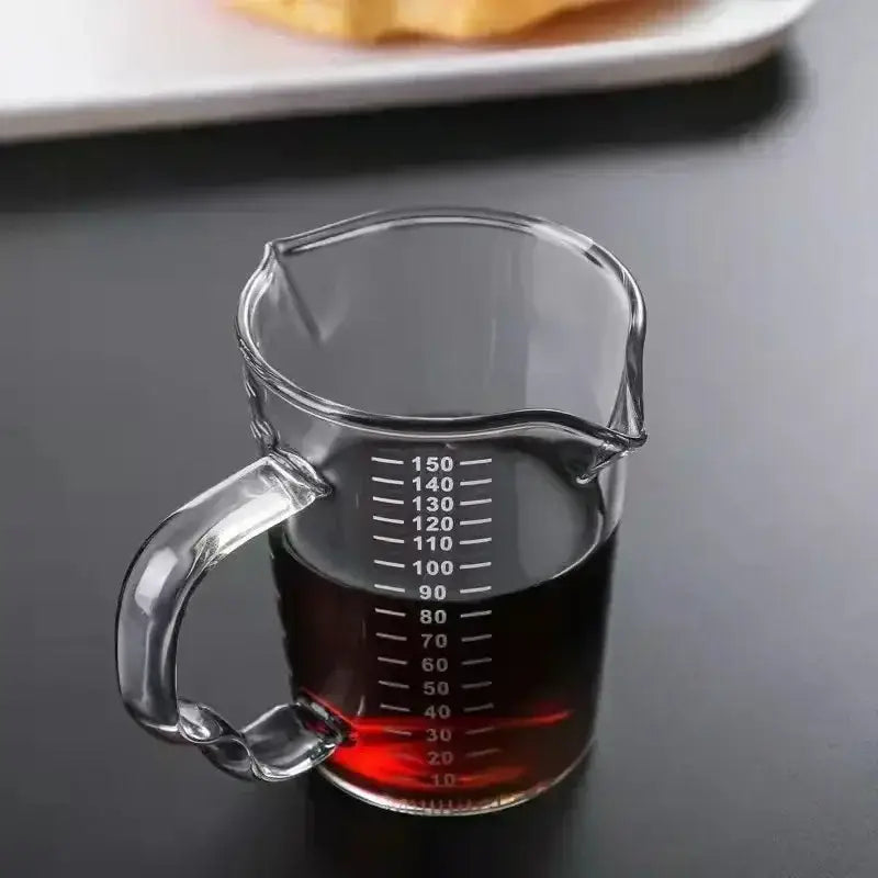 Clear glass espresso measuring cup with handle and spout marked in milliliters for precise kitchen use measuring cup