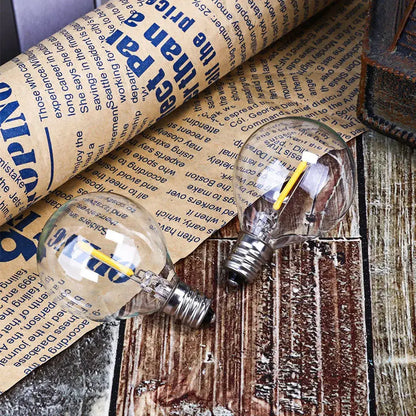 Two clear glass globe g40 led string lights with yellow filaments and metallic bases for decorbites g40 led string decor