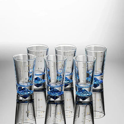 Clear glass liquor cup set with gold measurement markings and blue crystal-like bases by decorbites clear glass