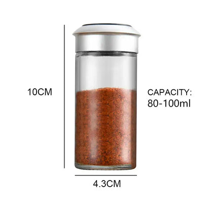 Clear glass rotating spice jar with silver lid filled with reddish-brown seasoning for decorbites rotating spice set