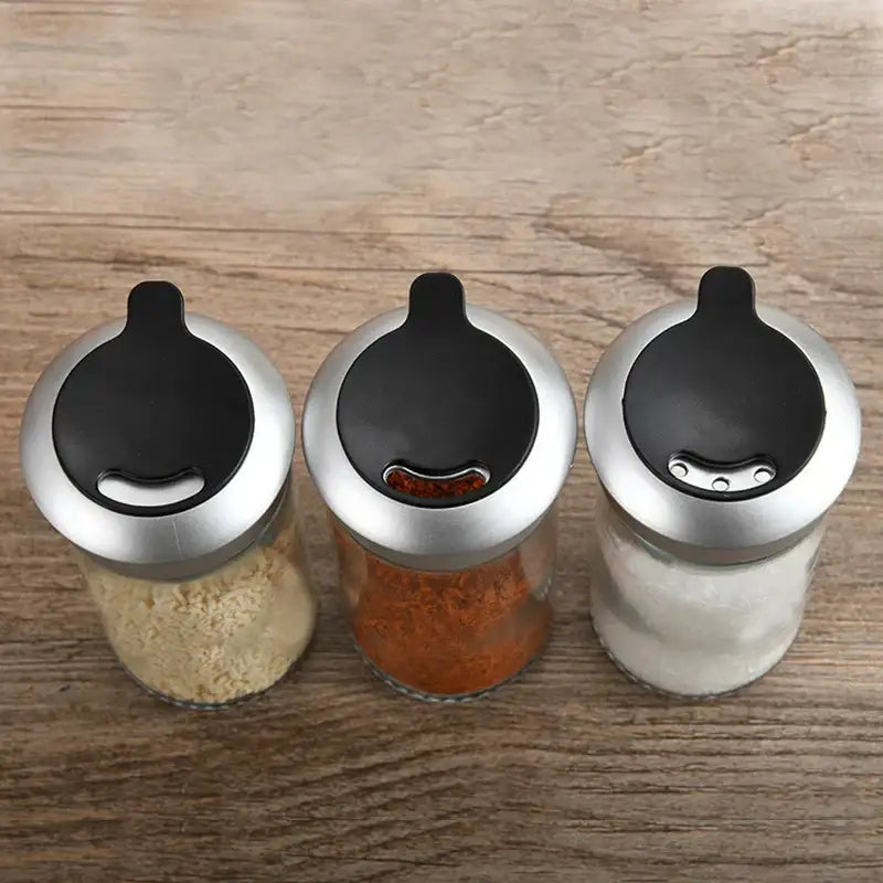 Set of three clear glass rotating spice jars with silver lids and black tops for kitchen seasoning by decorbites rotating spice