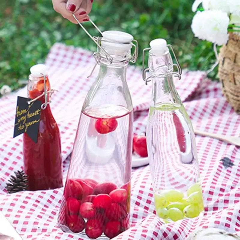 Clear glass storage bottle with swing top lid filled with red berries and water by decorbites glass storage