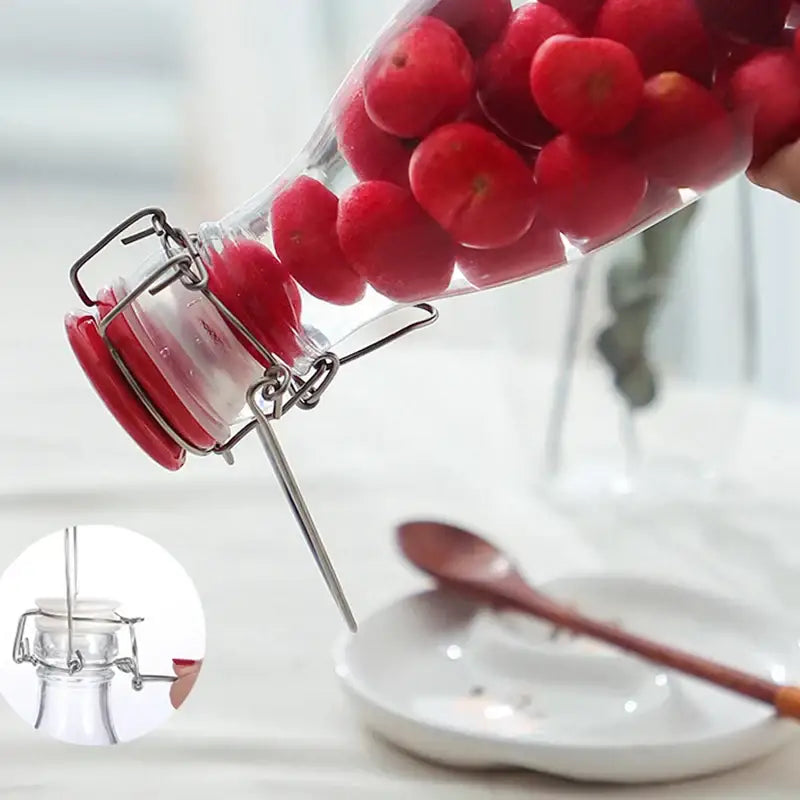 Clear glass storage bottle by decorbites with swing top lid red rubber seal filled with bright red cherries