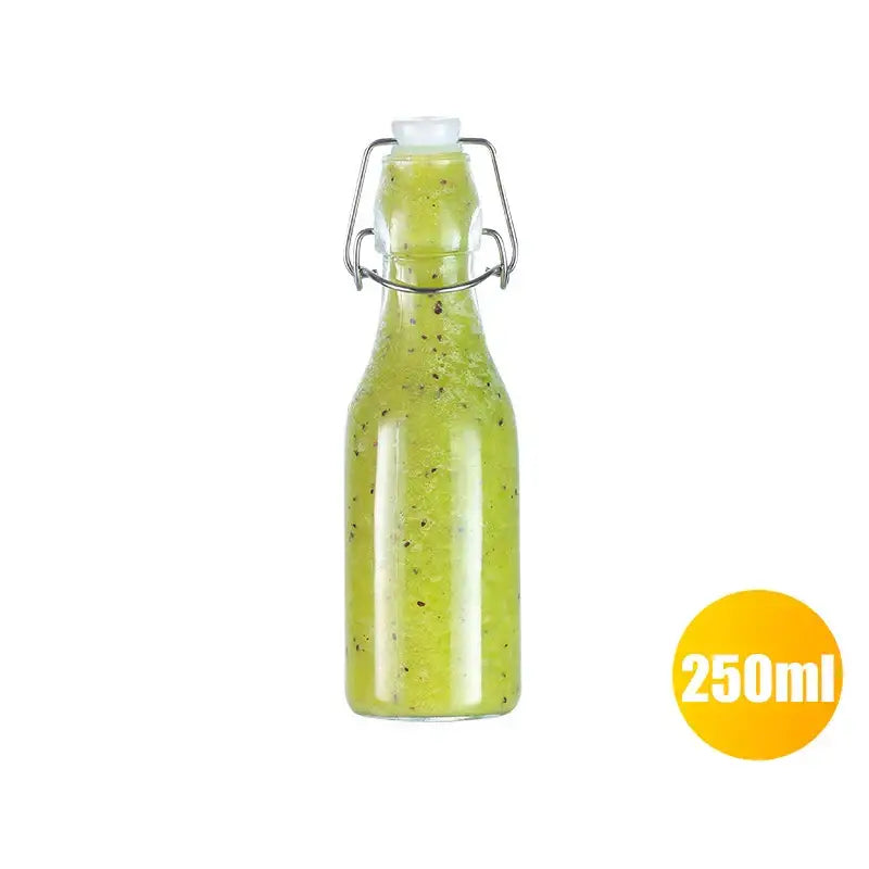 Clear glass storage bottle by Decorbites with silver metal swing top lid filled with green liquid and dark specks