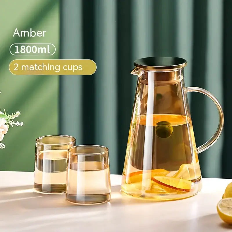 Amber glass juice kettle set with gold-toned lid and handle holding lemon-infused water decorbites glass juice pitcher