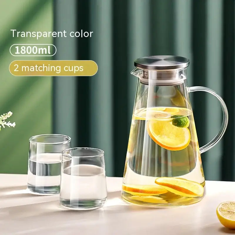Clear glass juice kettle with stainless steel lid and handle filled with lemon water from decorbites glass juice set