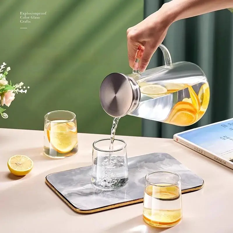 Clear gold glass juice kettle set featuring a clear glass pitcher with stainless steel lid filled with lemon water