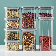 Clear decorbites hermetic food storage containers with gray lids filled with dried herbs and fruits for kitchen preservation