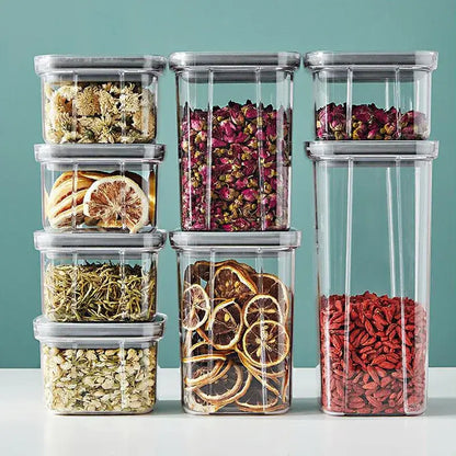 Clear decorbites hermetic food storage containers with gray lids filled with dried herbs and fruits for kitchen preservation