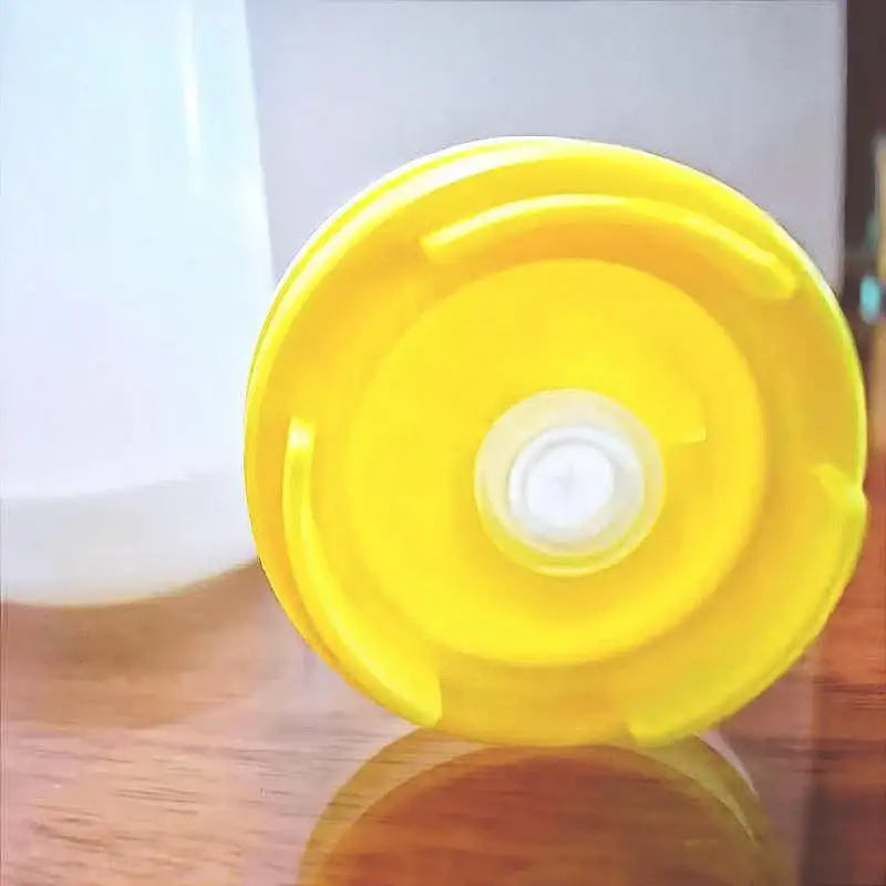 Bright yellow plastic lid with central white opening and ridges for clear red white and yellow tomato squeeze bottle kitchen set