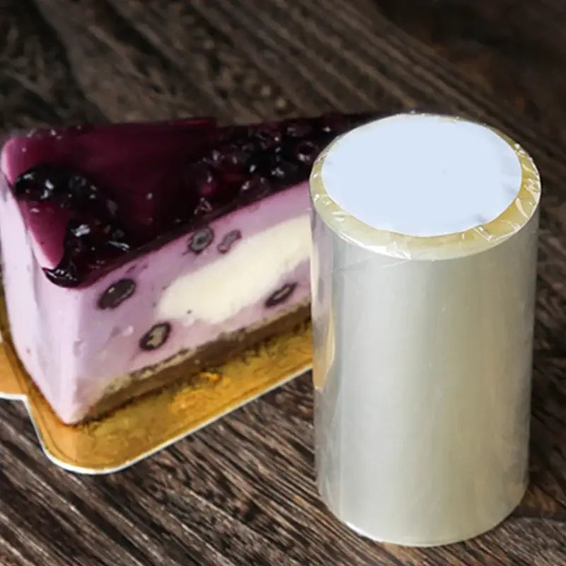 A roll of clear transparent cake edge wrap with white core and gold edge seal for decorbites cake mousse decorating