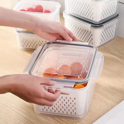 Clear white plastic fridge storage container with transparent lid, side handles, and ventilated drain basket by decorbites