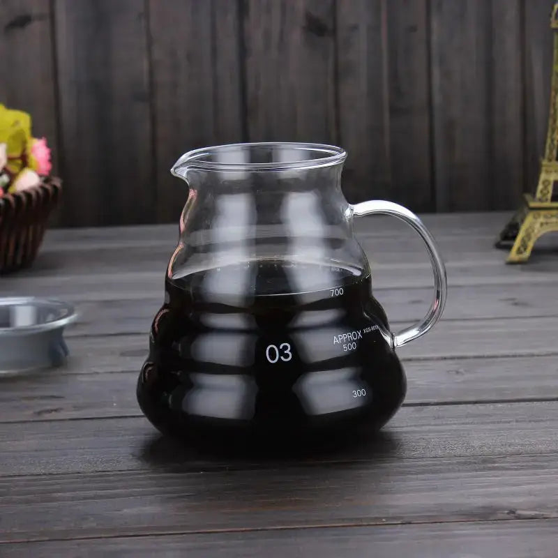 Clear glass coffee kettle with silver handle and measurement markings filled with dark liquid from decorbites cloud glass coffee