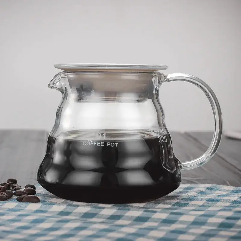 Clear glass cloud glass coffee kettle with silver handle and lid filled with dark brewed coffee by decorbites cloud glass