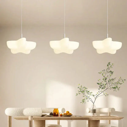 Three off-white cloud white modern pendant lights with matte finish hang above a wooden dining table decorbites cloud white chandelier