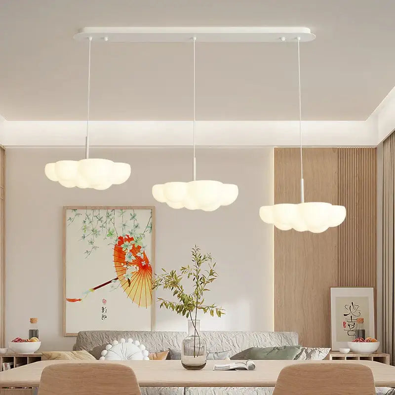 Three white cloud-shaped pendant lights of decorbites cloud white modern chandelier hang over kitchen island
