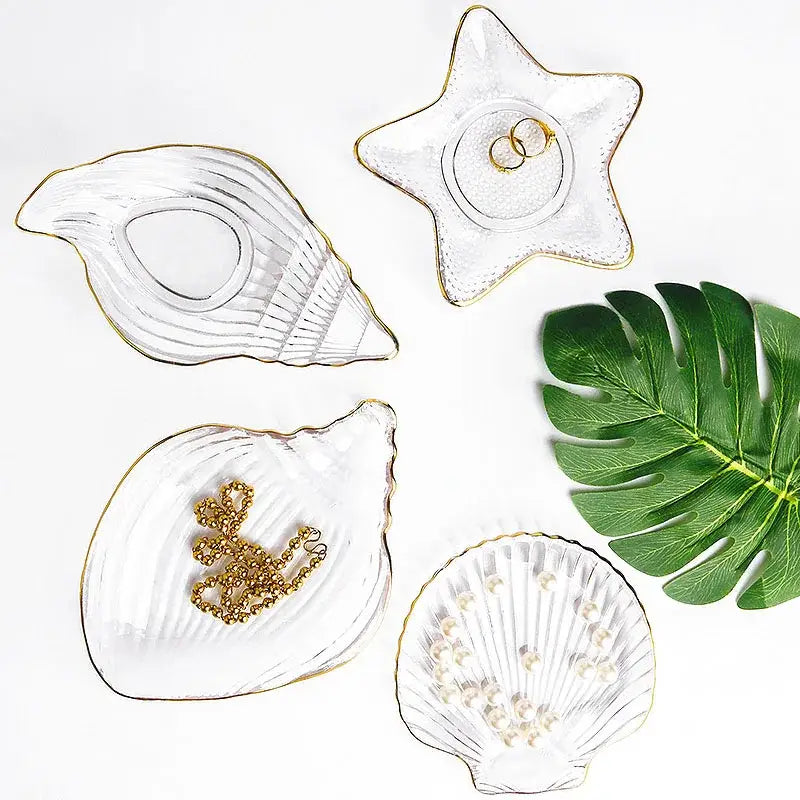 Clear glass dish plates and plate saucers shaped like seashells and starfish with gold trim in coastal blue tones