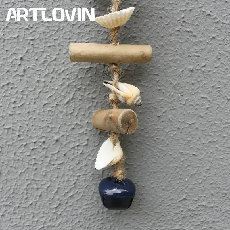A rustic coastal blue and white drift wood bells ornament featuring bamboo, seashells, and a navy blue bell hanging decor