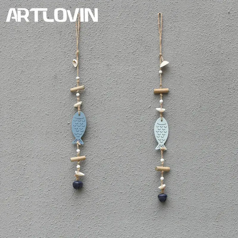 Two light blue coastal fish drift wood bells with scalloped fins hanging from natural twine with white beads and charms