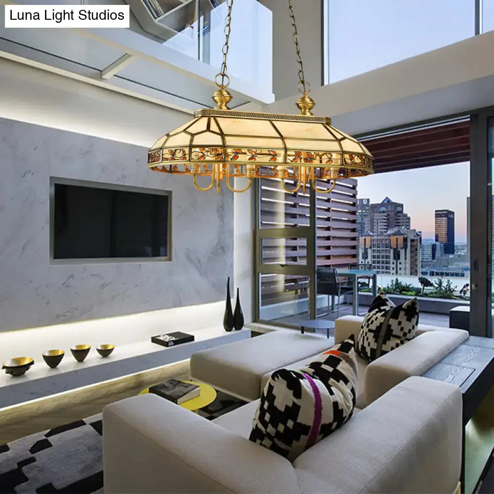 Gold-toned colonial style pendant light with intricate floral glass shade and warm glowing illumination from decorbites