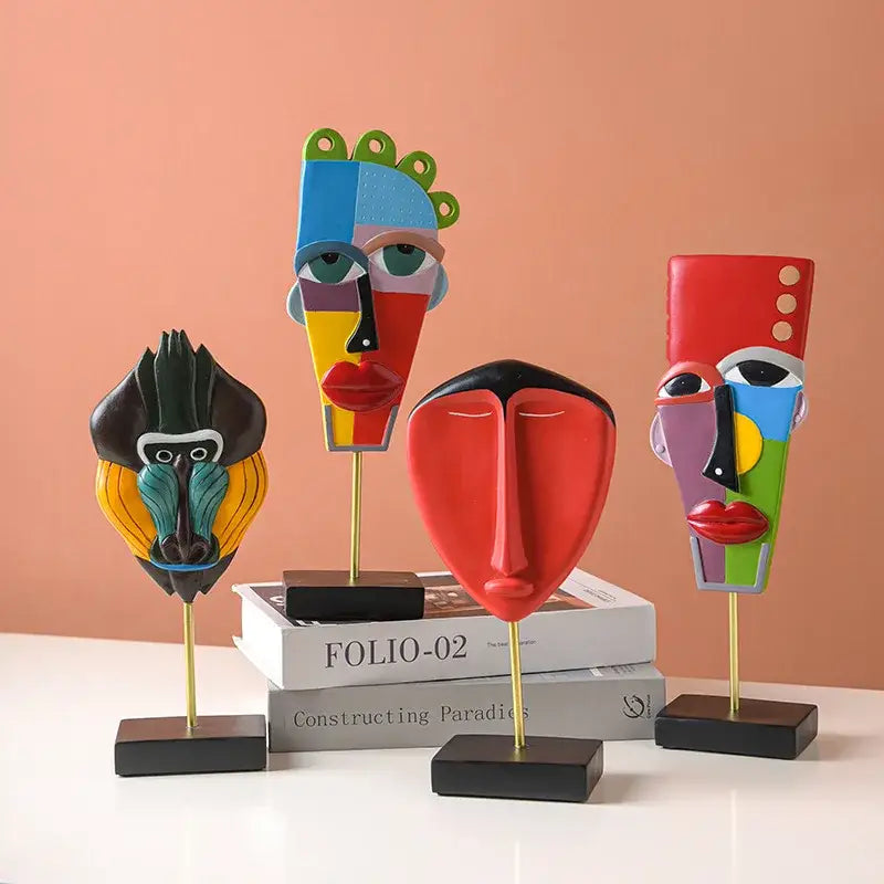 Four colorful african abstract face monkey sculptures with gold stands and black bases for living room decorbites decor