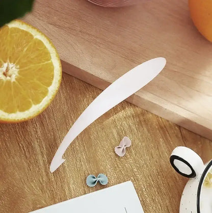 White plastic decorbites citrus zester spoon resting on wooden surface in citrus zester peeler knife set of 4