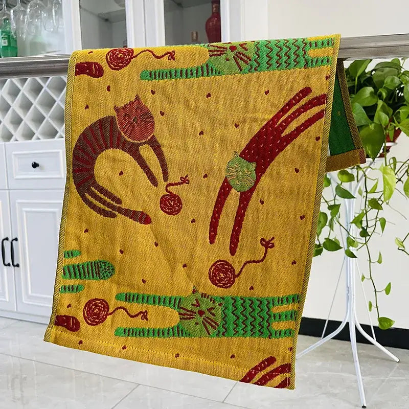 A vibrant yellow decorbites cat gauze hand towel featuring playful red and green stylized cats with yarn balls