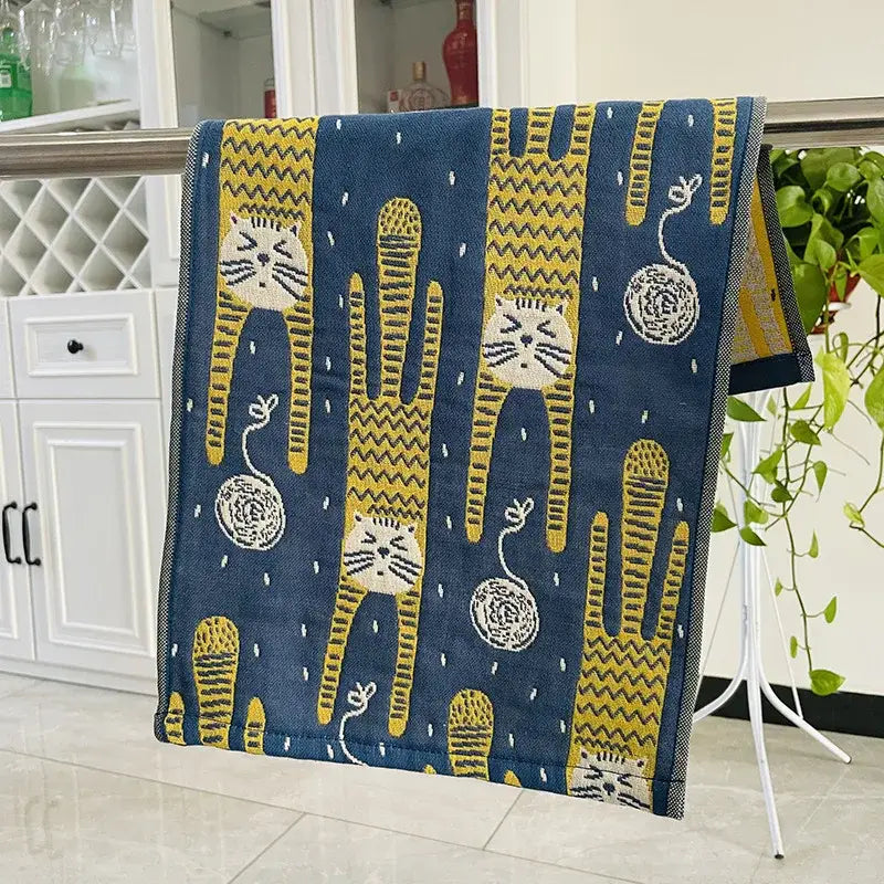 Blue cat gauze hand towel with yellow and white cartoon cats hanging on metal rack from decorbites hand towels set