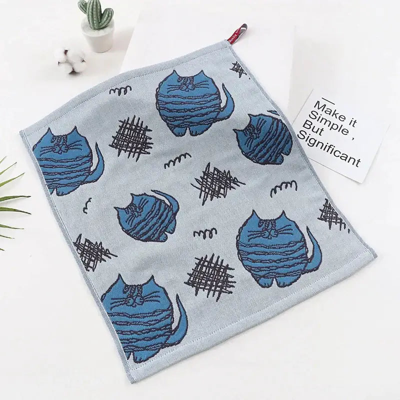 Light blue embroidered cat gauze hand towel with playful cartoon cats and black scribble patterns from decorbites set