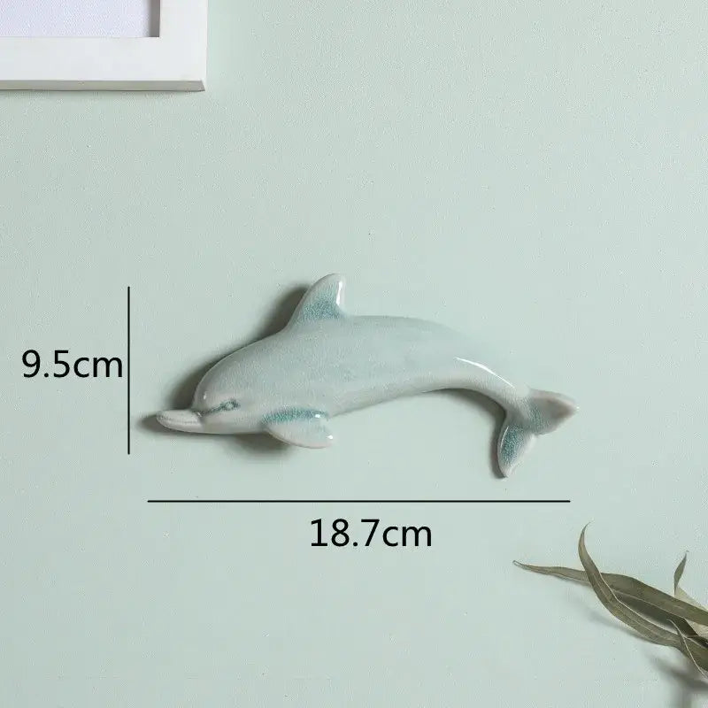 A sleek light blue ceramic dolphin fish ocean wall decoration with glimmering accents for children’s room decorbites wall decor