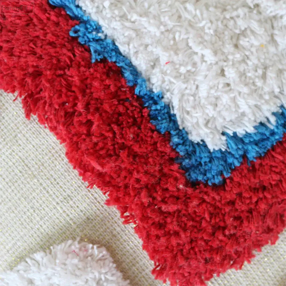 A plush textured rug with bold red and white sections separated by a vibrant blue border for boho tassel macrame decor